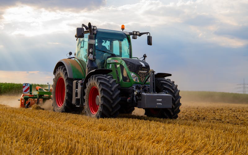 GmbH-Rechtsschutzversicherung für Landwirtschaft — Traktor auf einem Feld bei der Ernte